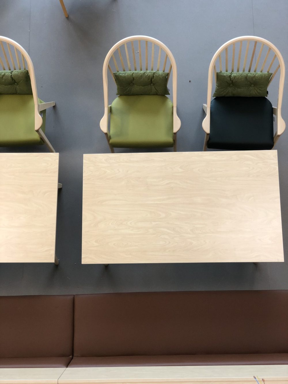 Sitteplasser i inngangsparti på omsorgs- og aktivitetssenter i Mosvik. Grønn og brun fargepalett på møblene. 