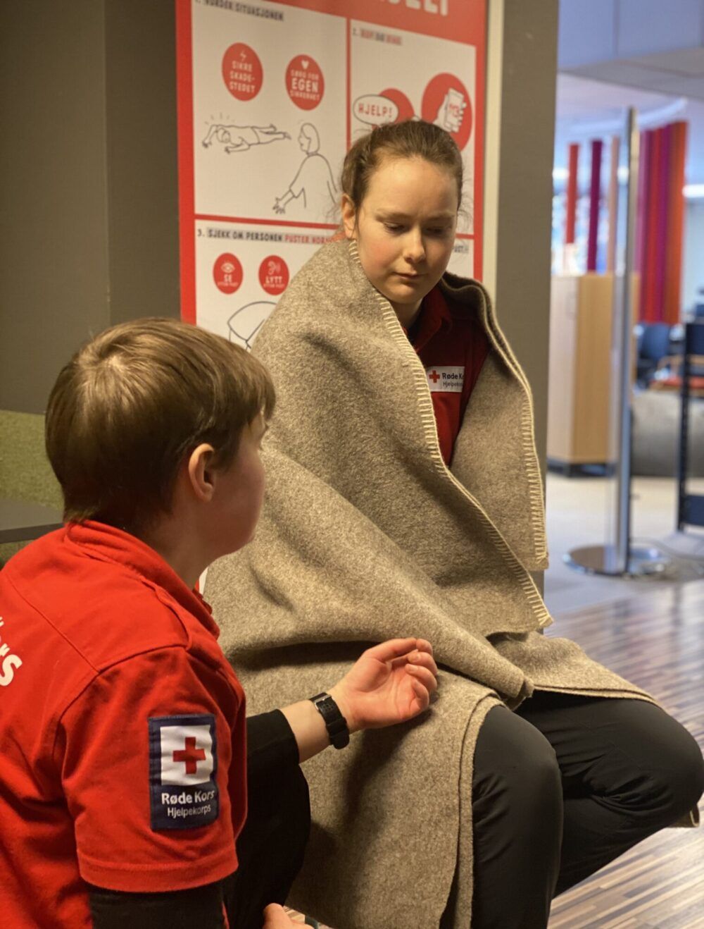 Damene fra Røde Kors viser at man må holde offeret varmt ved feks ved å legge et teppe over personen.