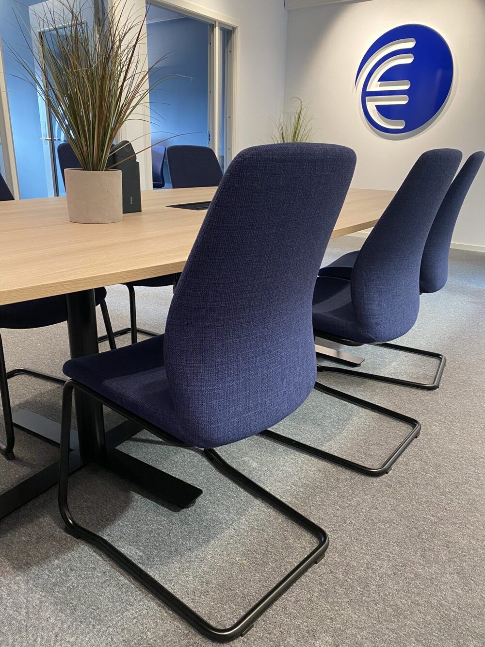 Blå møteromsstoler hos Enor Verdal. Møteromsbord med topplate i laminat eik.