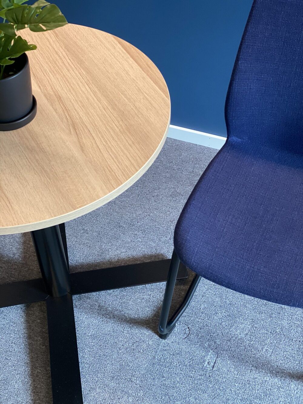 Sosial sone på kontor med rundt bord og to stoler.